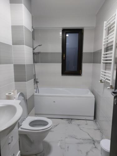 een witte badkamer met een toilet en een wastafel bij Bya Brown Residence in Valea Lupului