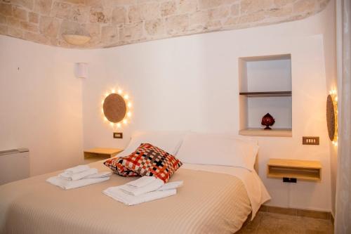 a white bedroom with a bed with towels on it at Pavì Trulli e Suites in Locorotondo