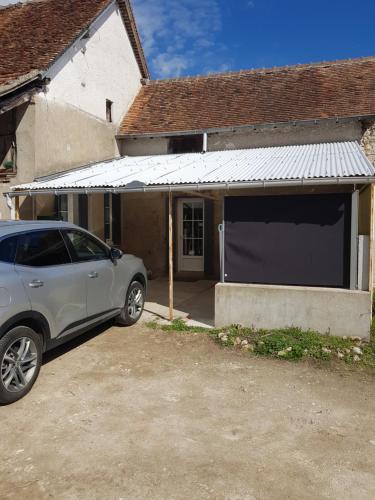 a car parked in front of a garage at marie-Emma wifi gratuite in Beaulieu-sur-Loire