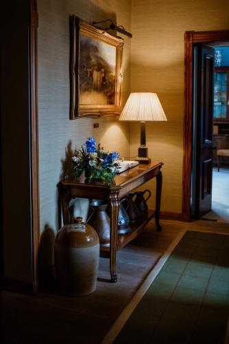 a room with a table with a lamp on it at Links House at Royal Dornoch in Dornoch
