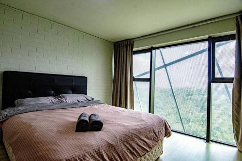 ein Schlafzimmer mit einem Bett mit einem Paar Schuhe darauf in der Unterkunft Bathtub Soho, Forest View Empire Damansara in Petaling Jaya