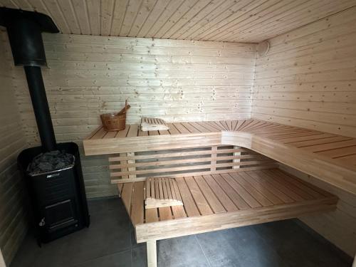 an empty sauna with two benches and a stove at Wellness at Sea in Egmond aan Zee