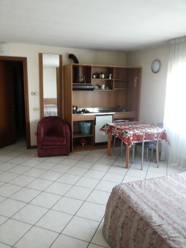 a living room with a table and a kitchen at Hotel Residence La Fontana in Mariano Comense