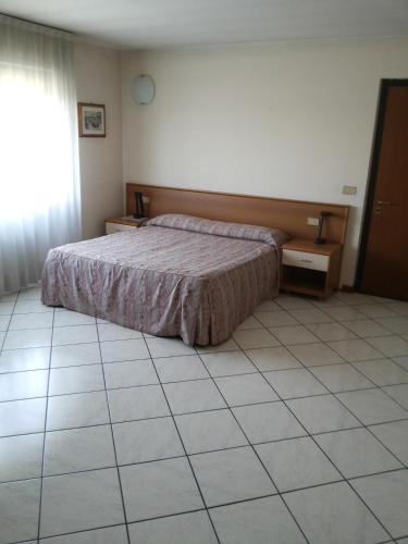 a bedroom with a bed and a tiled floor at Hotel Residence La Fontana in Mariano Comense