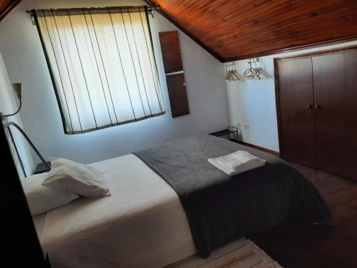 una camera con un grande letto e una finestra di Casas do Caminho Velho a Ribeira de Pena