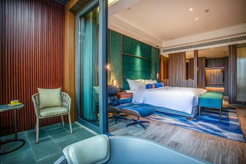 um quarto de hotel com uma cama, uma secretária e cadeiras em Gao Shi Di Hot Spring Hotel Yangzhou em Yangzhou