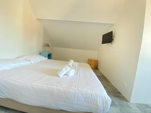 Un dormitorio con una cama blanca con toallas. en Hotel et Studios Le Marina Baie de La Baule en Pornichet