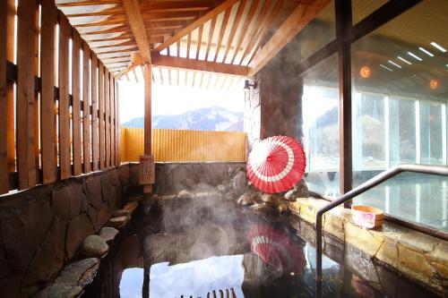 a hot spring in a building with a fan at Ooedo Onsen Monogatari Kounkaku in Osaki