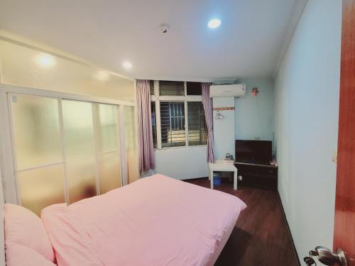 a bedroom with a white bed and a window at Easy B&B in Jiufen