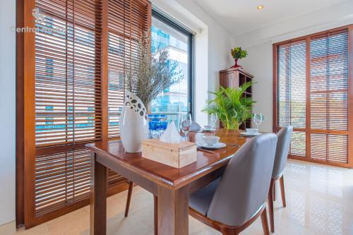 a dining room with a table and chairs and windows at Park view Avalon Apartment District 1 HCM City in Ho Chi Minh City