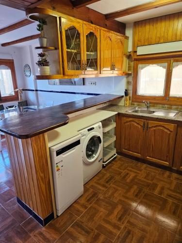 a kitchen with a washer and dryer under a counter at Sanchis Guarner Bajo Solo Familias Serviplaya in Playa de Xeraco