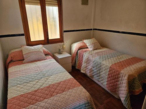 a bedroom with two beds and a window at Sanchis Guarner Bajo Solo Familias Serviplaya in Playa de Xeraco