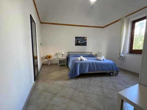 - une chambre avec un lit bleu et une fenêtre dans l'établissement Angolo del Mare - Casa Corallo Nero, à Favignana