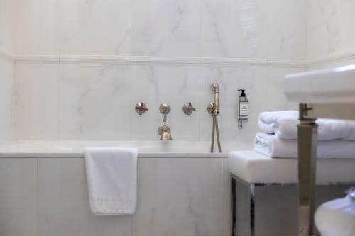 a bathroom with a tub and a sink and towels at Hôtel Les Mouettes - Teritoria in Ajaccio