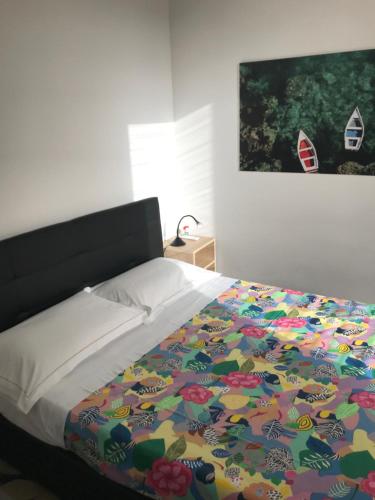 カターニアにあるVico Santa Filomenaのベッドルーム1室(カラフルな掛け布団付きのベッド1台付)
