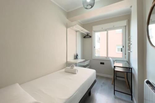 a white room with a bed and a window at Confy 3 bedroom apartment in Sant Andreu in Barcelona