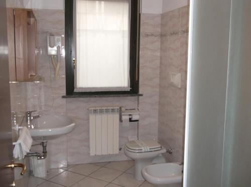 a bathroom with a toilet and a sink at Hotel Residence La Fontana in Mariano Comense