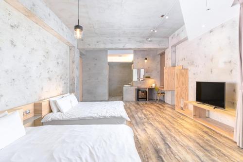 a bedroom with two beds and a flat screen tv at 日月潭山慕藝旅 Sun Moon Inn in Yuchi