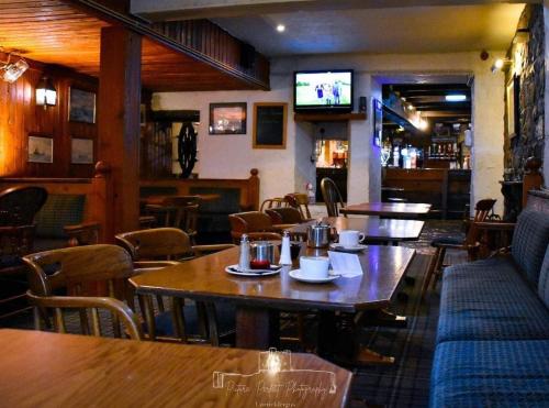 ein Restaurant mit Tischen und Stühlen und einem Fernseher in der Unterkunft Dobbins Inn in Carrickfergus