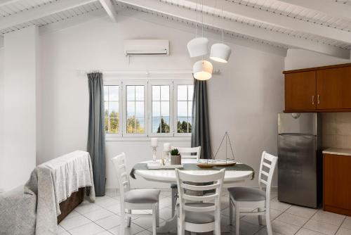 a kitchen and dining room with a table and chairs at The Seaview Corner Apartments by Konnect, Ipsos Corfu in Ýpsos