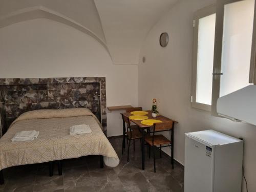 a bedroom with a bed and a table and a window at SUITE AGATA in Gallipoli