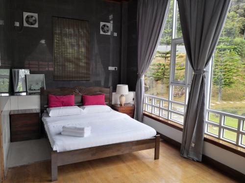 a bedroom with a bed and a large window at Sling N Stone Vacation Homes, Mt Kinabalu in Kundasang