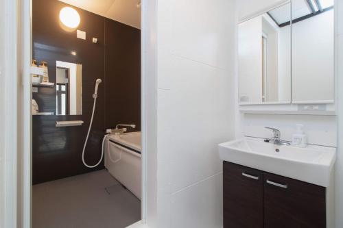 a white bathroom with a sink and a bath tub at FTH maroon 4min to station in Azagawa