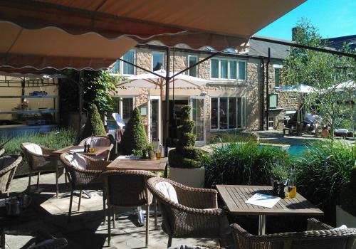 een openluchtrestaurant met tafels en stoelen en een parasol bij Feversham Arms Hotel & Verbena Spa in Helmsley