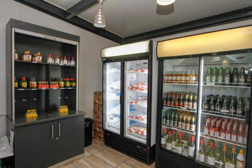a store with two refrigerators and bottles of beer at SleepOver Komatipoort in Komatipoort