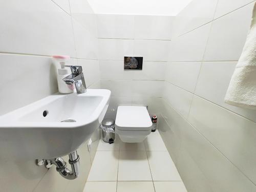 een witte badkamer met een wastafel en een toilet bij Ani's Home newly built apartment in Boedapest
