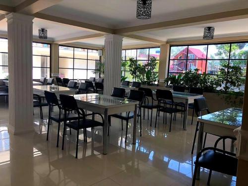 - une salle à manger avec des tables, des chaises et des fenêtres dans l'établissement Del Mar, à Ureki