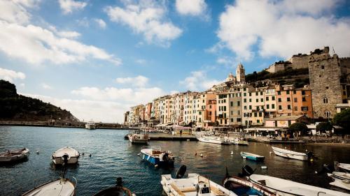 un gruppo di imbarcazioni ormeggiate in un fiume con edifici di 23Apartments a La Spezia