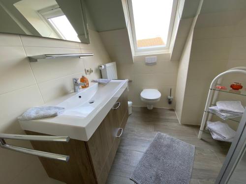 La salle de bains est pourvue d'un lavabo et de toilettes. dans l'établissement Ferienwohnungen Stips, à Tönning
