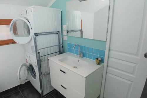 een badkamer met een wastafel en een wasmachine bij Comme à la maison in Cenon