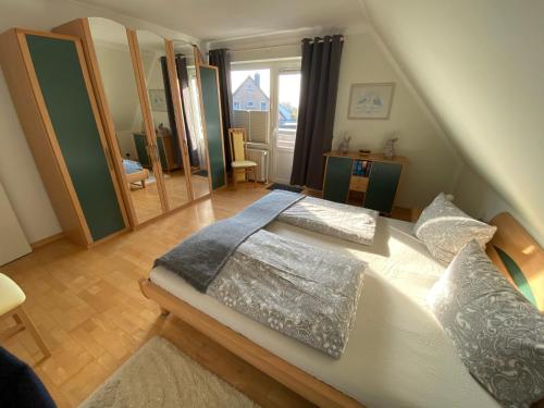 - une chambre avec un grand lit blanc et des oreillers dans l'établissement Ferienwohnungen Stips, à Tönning