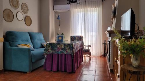 a living room with a blue couch and a table at Mi Casa En Benamahoma in Benamahoma