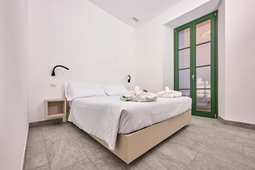 una camera bianca con un letto e una finestra di Cà del Lasco - Modern Apartments in Classic Villa a Bellano