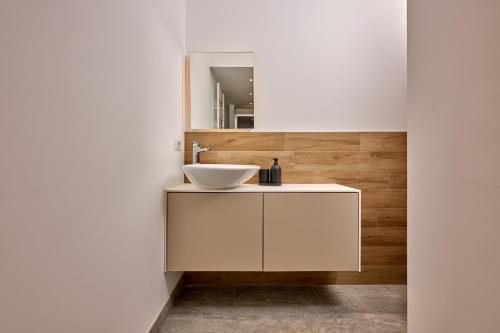 een badkamer met een witte wastafel en een spiegel bij Cà del Lasco - Modern Apartments in Classic Villa in Bellano