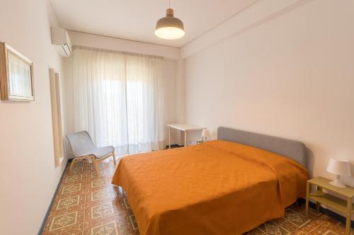 a bedroom with a bed with an orange blanket at CASA ROSARIA in Cefalù