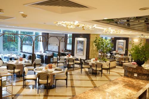 a restaurant with tables and chairs and windows at Leeden Hotel Guangzhou in Guangzhou