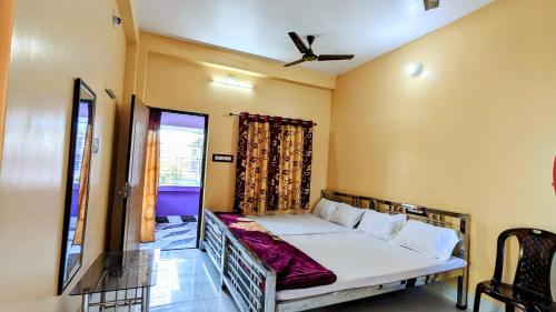 - une chambre avec un lit et un ventilateur de plafond dans l'établissement Sundarban Tulip Homestay, Pakhiralay, WB, à Purbbadulki
