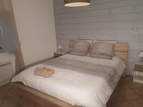 um quarto com uma cama grande com lençóis brancos e almofadas em gite dentelles em Loriol-du-Comtat
