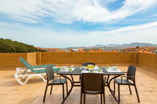 a patio with a table and chairs on a roof at Apartamentos Solamaza in Isla