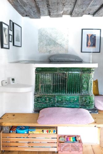 a room with a green fireplace with a wooden table at Hiša Borov Gaj in Mojstrana