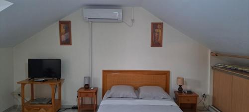 1 dormitorio con 1 cama y TV en una habitación en Logement spacieux deux pièces à Baie Mahault, en Baie-Mahault