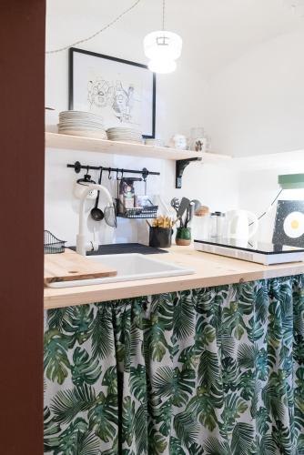 a kitchen sink with a green leafy wallpaper at Hiša Borov Gaj in Mojstrana