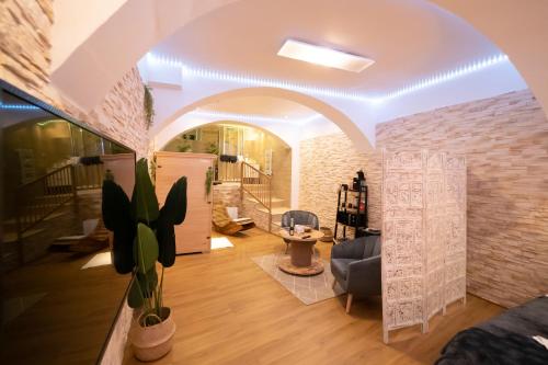 a living room with an archway and a couch and a chair at Le Spa de la Cathédrale - Jacuzzi - Sauna - Champagne - Netflix - Wifi in Troyes