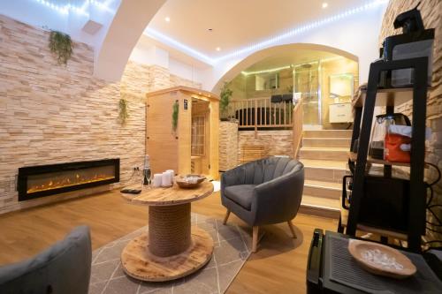 a living room with a fireplace and a table and chairs at Le Spa de la Cathédrale - Jacuzzi - Sauna - Champagne - Netflix - Wifi in Troyes