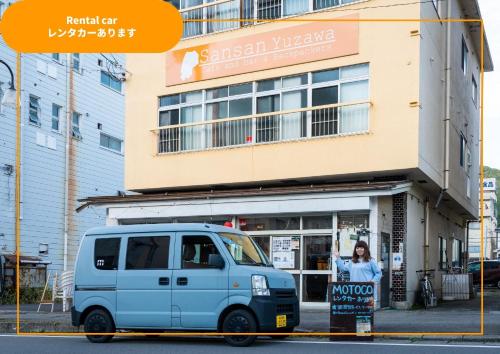 une camionnette garée devant un bâtiment dans l'établissement Sansan Yuzawa Backpackers, à Yuzawa