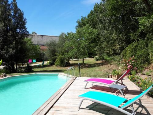uma piscina com duas cadeiras e uma mesa em gite dentelles em Loriol-du-Comtat